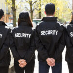 Rear View Of Security Guards Standing In A Row